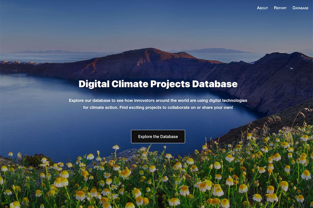 Screenshot of Digital Climate Projects Database home page. Background image: View of a bay with dark blue water and curving brown headland. Blue sky and in the foreground a mass of white and yellow flowers.