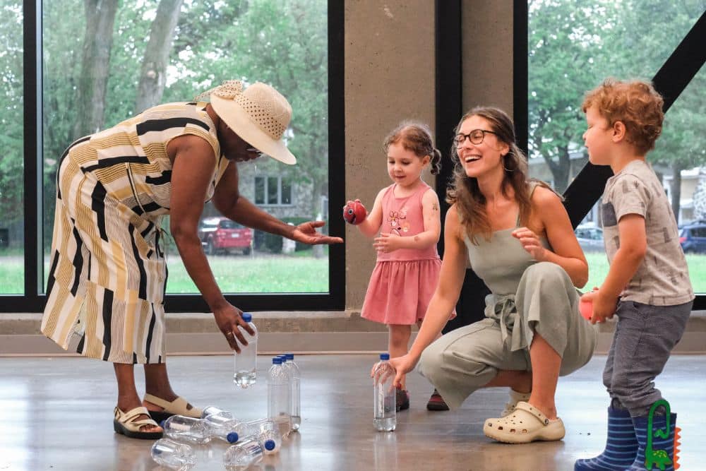 Olivia with a woman and a young child during a workshop with water bottles.